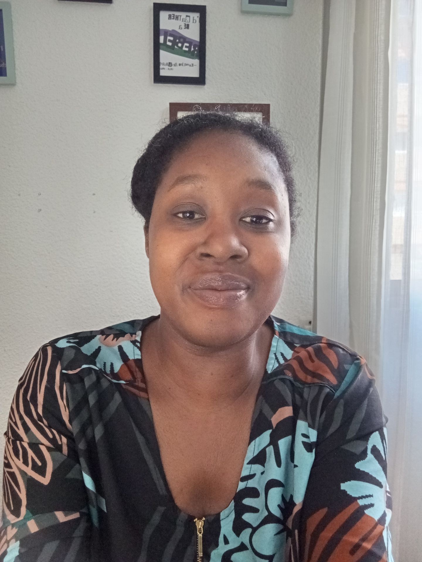 Image of black woman smiling to the camera with her lips closed