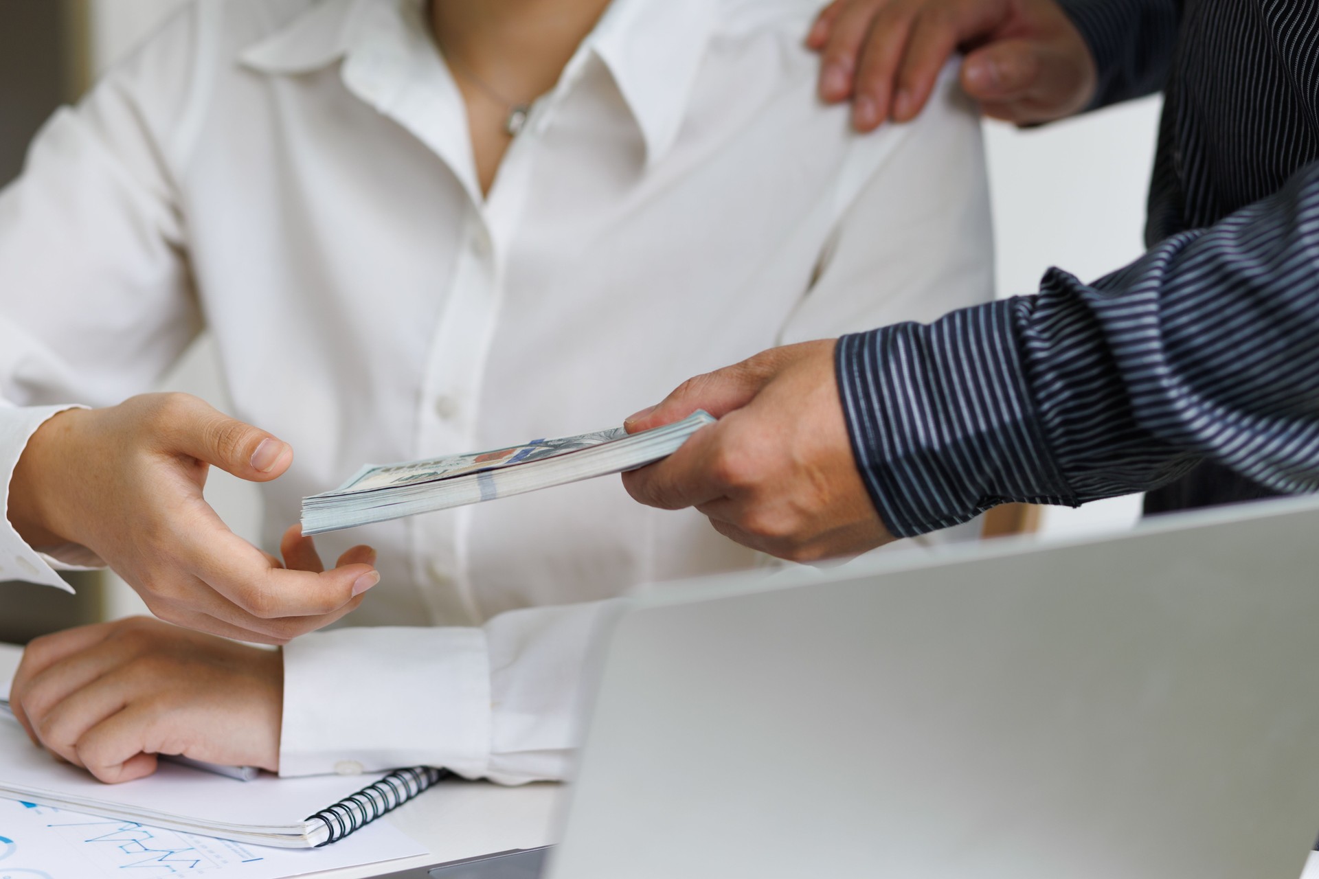 Businessman giving wages to colleagues.