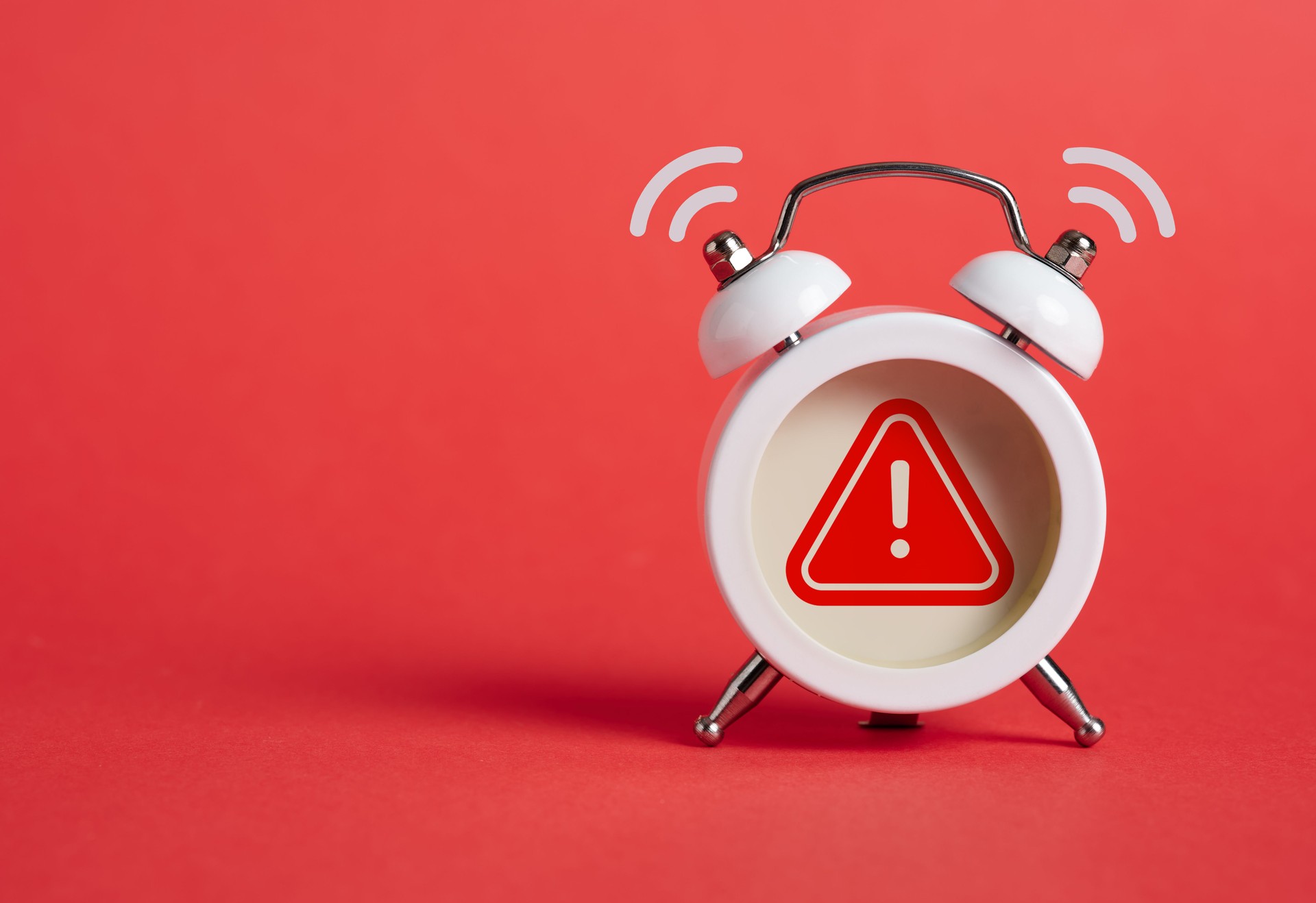 Caution, warning or exclamation sign inside of an alarm clock.